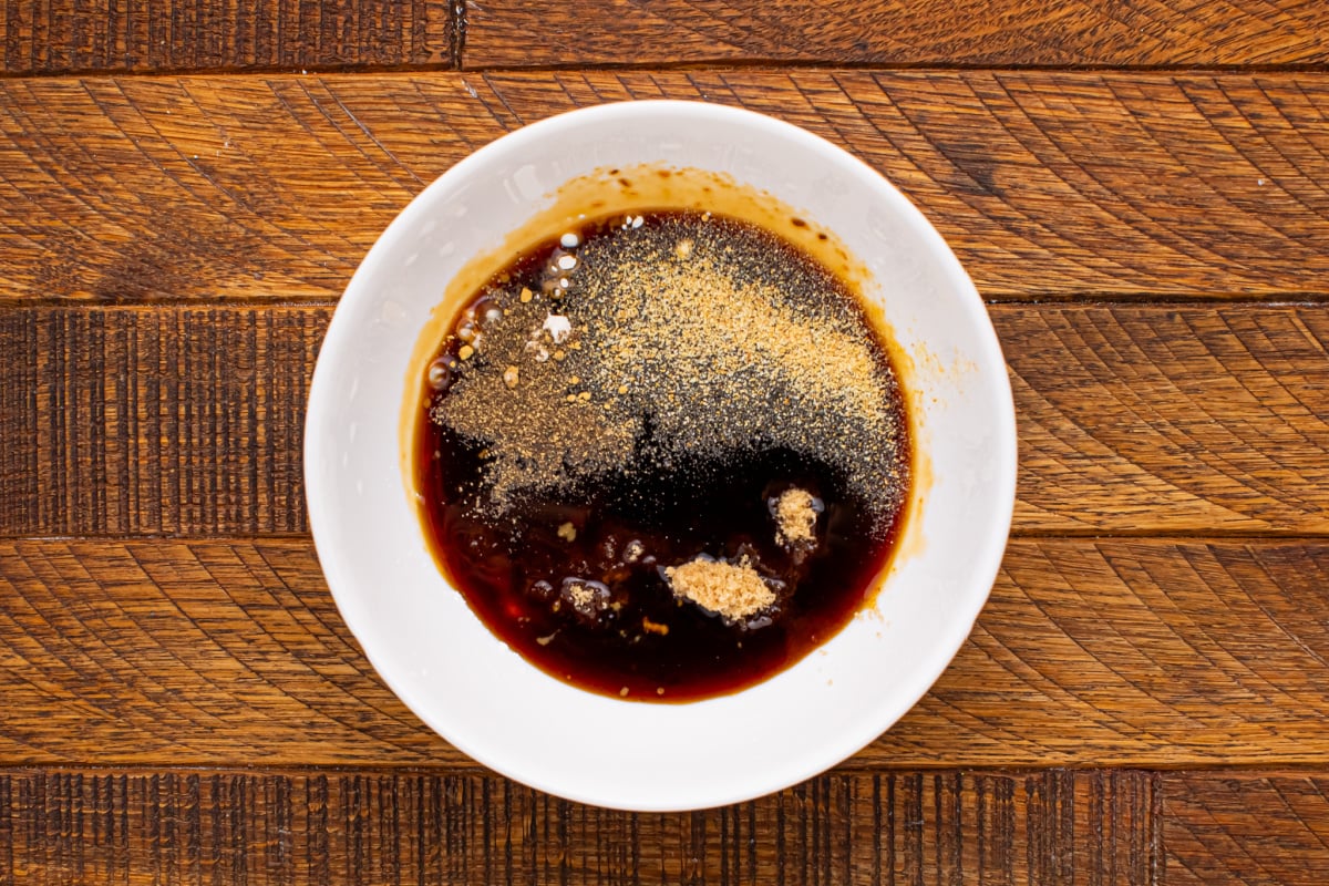 Soy sauce in a small bowl, brown sugar, garlic powder, grated ginger, black pepper and cornstarch